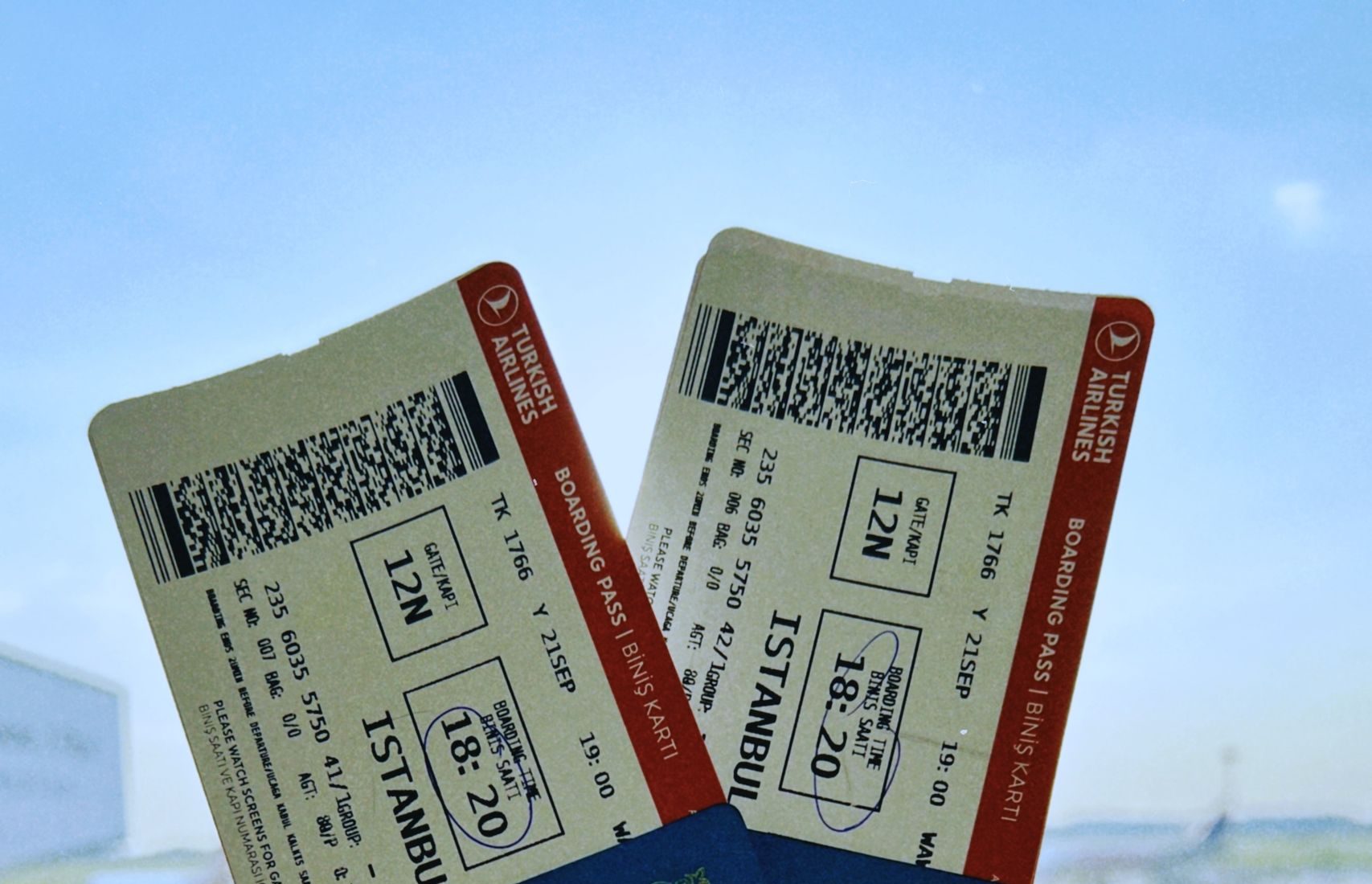 A Kazakhstan passport holds two airline tickets against an airport backdrop in Warsaw, Poland.