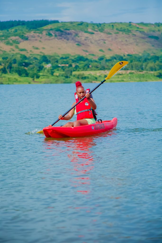 A man kayaking on a peaceful river surrounded by hills. Outdoor adventure in nature.