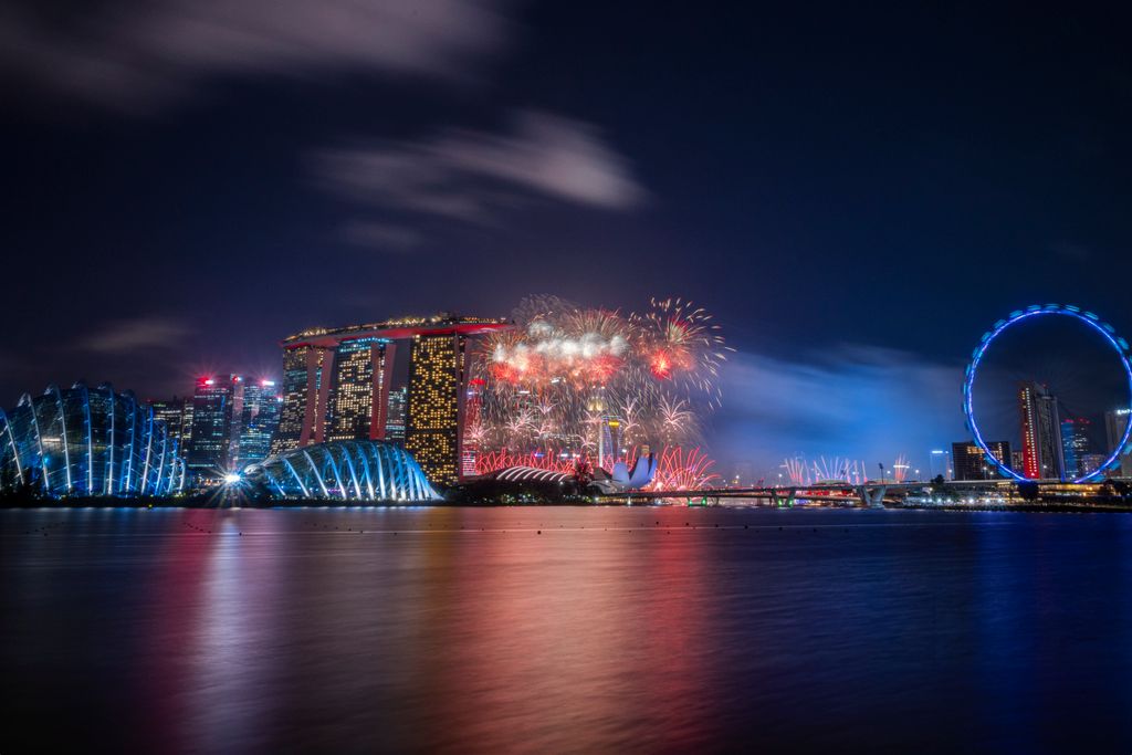 Dazzling fireworks light up the iconic Singapore skyline featuring the Marina Bay Sands and Singapore Flyer.