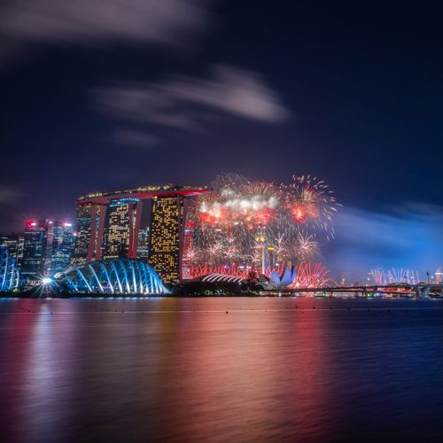 Dazzling fireworks light up the iconic Singapore skyline featuring the Marina Bay Sands and Singapore Flyer.