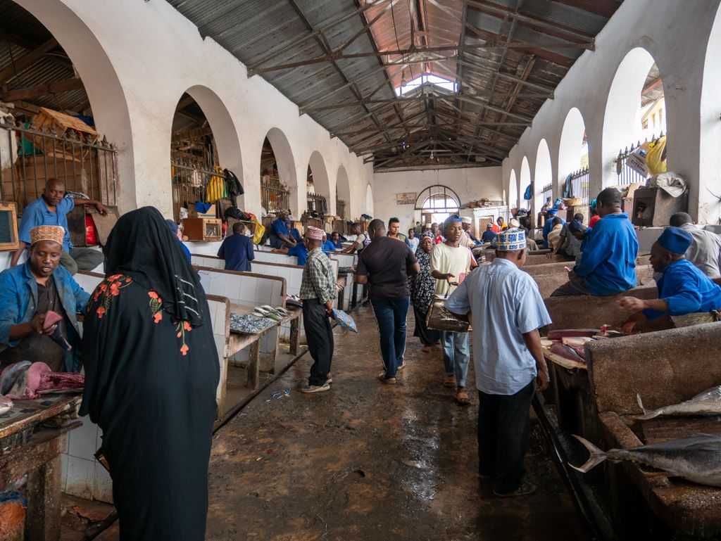 People engaged in lively trade inside a spacious fish market hall, showcasing local culture.