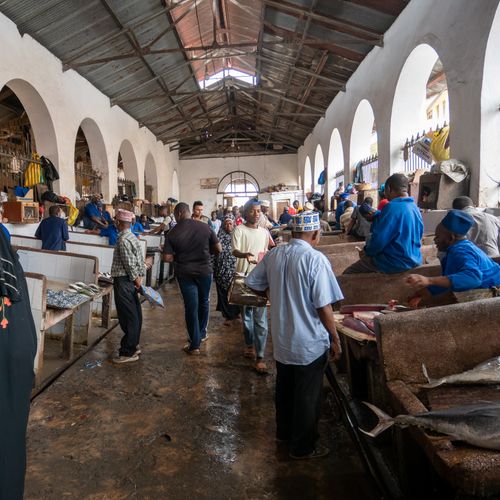 People engaged in lively trade inside a spacious fish market hall, showcasing local culture.