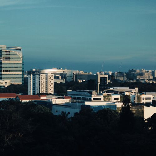 Skyline of Singapore featuring modern architecture under a clear blue sky.